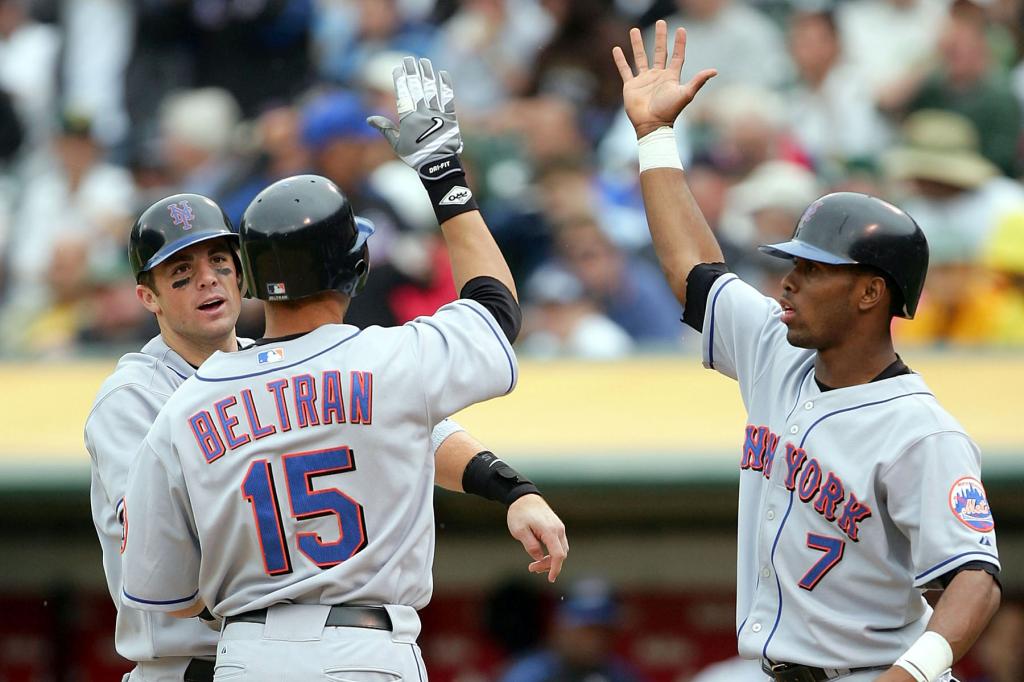Carlos Beltran #15 of the New York Mets is congratulated by teammates David Wright #5 and Jose Reyes #7 after batting them in with a three-run home run in the fifth inning against the Oakland Athletics at McAfee Coliseum on June 16, 2005 in Oakland, California. 