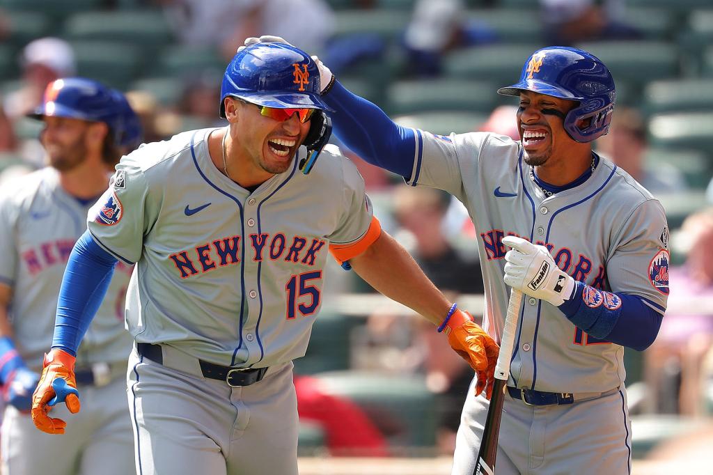 Tyrone Taylor #15 of the New York Mets reacts with Francisco Lindor #12 after hitting a grand slam in the ninth inning against the Atlanta Braves at Truist Park on April 11, 2024 in Atlanta, Georgia.