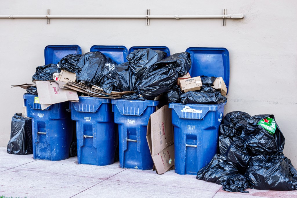 Overflowing blue recycling trash cans on Miami Beach, Florida