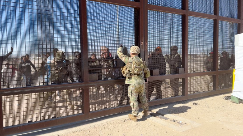 Migrants rush the border wall in El Paso, Texas