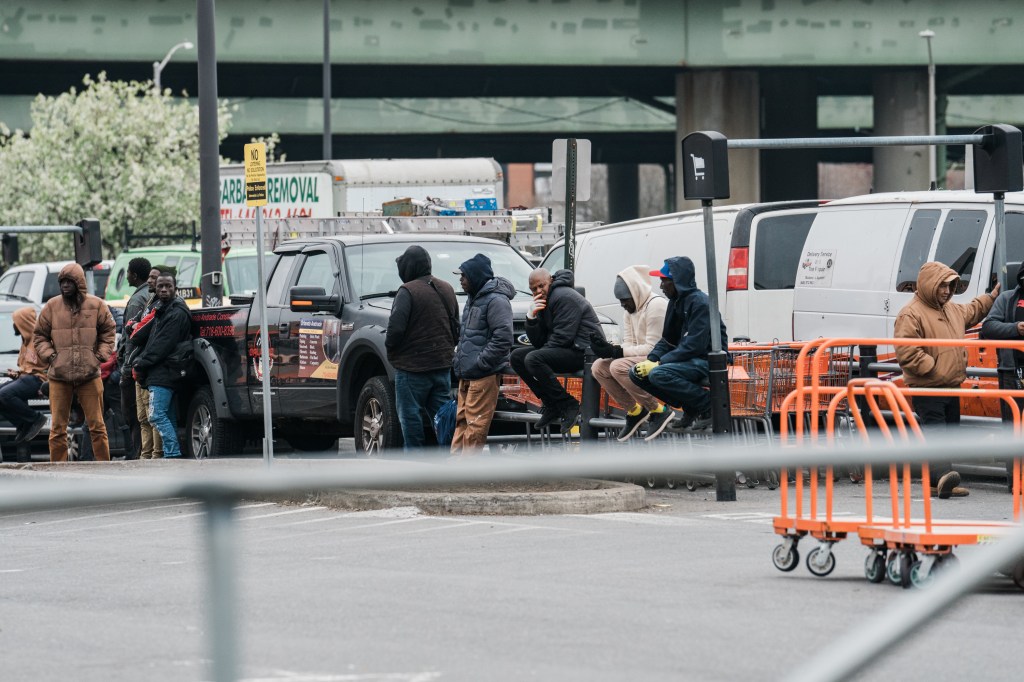 Ten migrant men flood the parking lot of the Home Depot in Throggs Neck, The Bronx