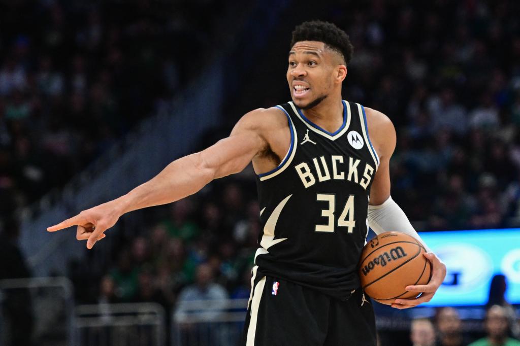 Milwaukee Bucks forward Giannis Antetokounmpo holding a basketball and calling a play during a game against the Boston Celtics