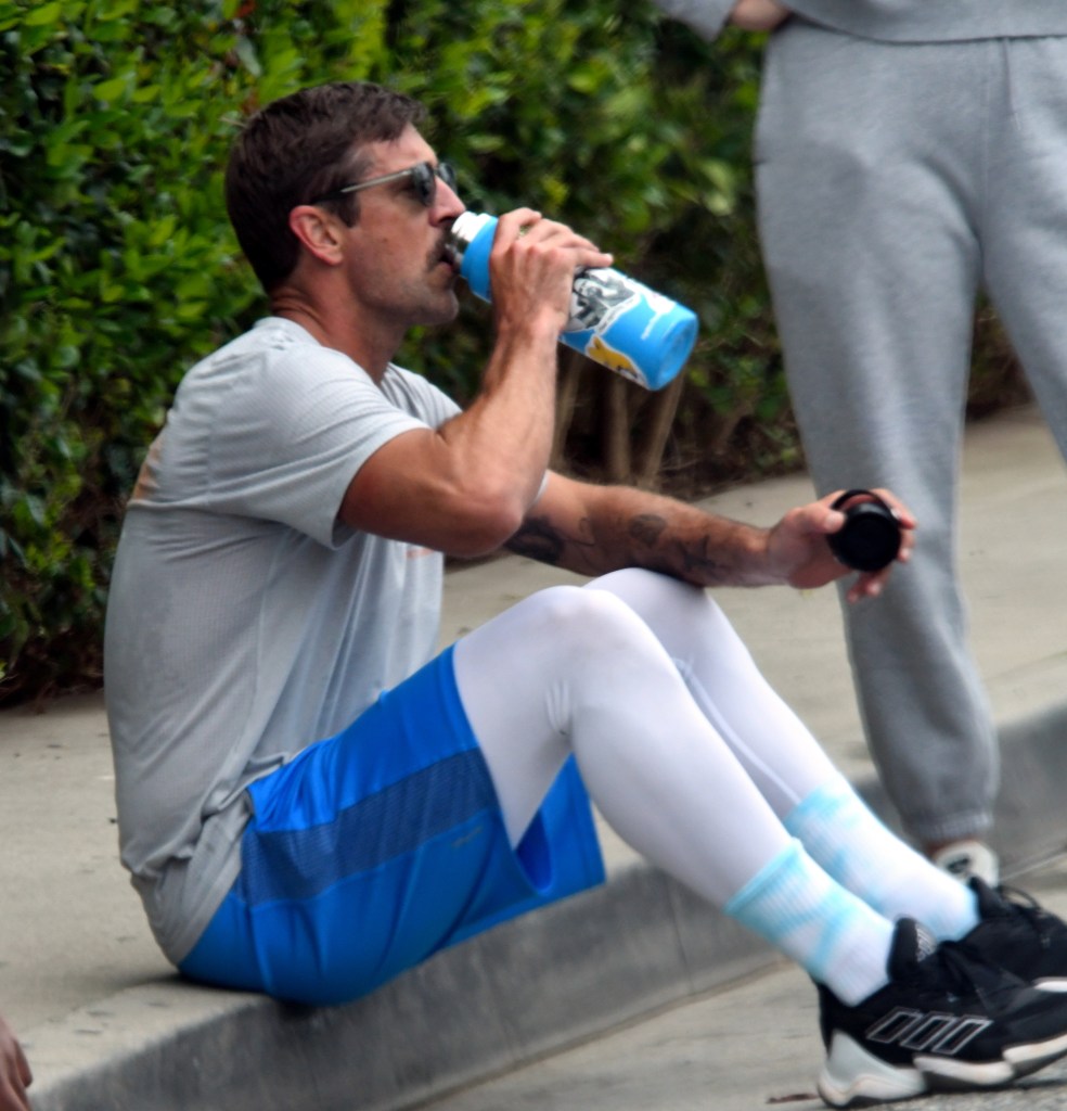 Jets quarterback Aaron Rodgers hydrates after doing a grueling workout with the USC Football team at the Santa Monica Stairs in Santa Monica, Calif.