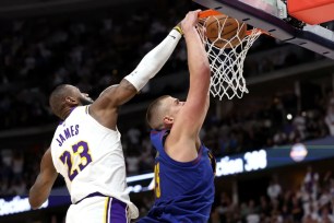 Nikola Jokic, who scored 32 points and grabbed 12 rebounds, slams home a dunk past LeBron James during the Nuggets' 114-103 Game 1 win over the Lakers