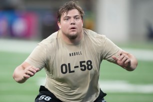 Oregon offensive lineman Jackson Powers-Johnson running on a field during the 2024 NFL Combine at Lucas Oil Stadium