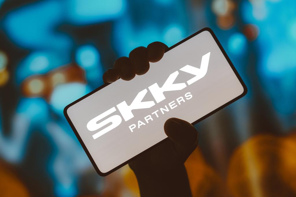 Photo illustration of SKKY Partners logo displayed on a smartphone screen
