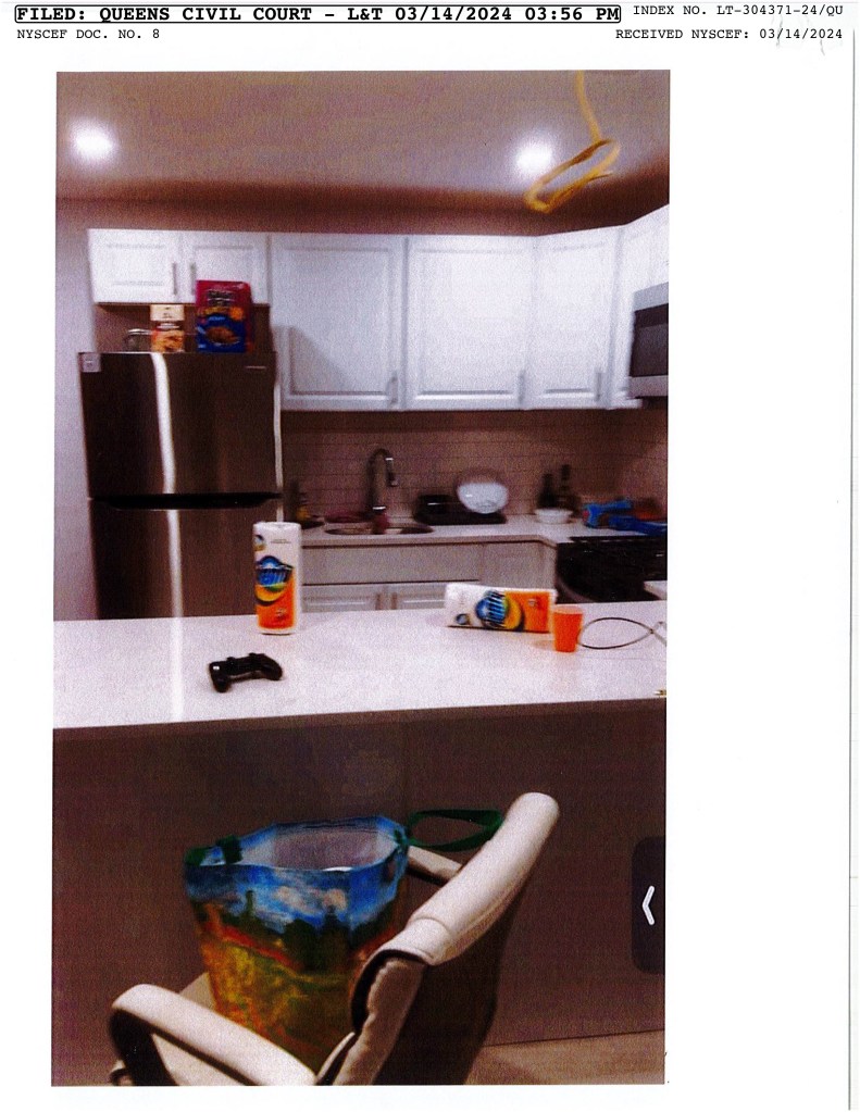 A kitchen with a refrigerator and a vacuum cleaner at 138-03 Lakewood Ave, related to a court case of wrongful eviction.