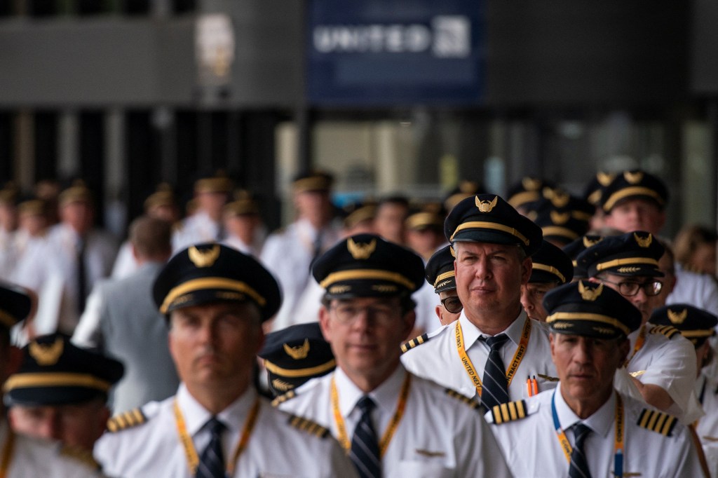 United Airlines pilots in uniform participating in an informational picket at Newark Liberty International Airport