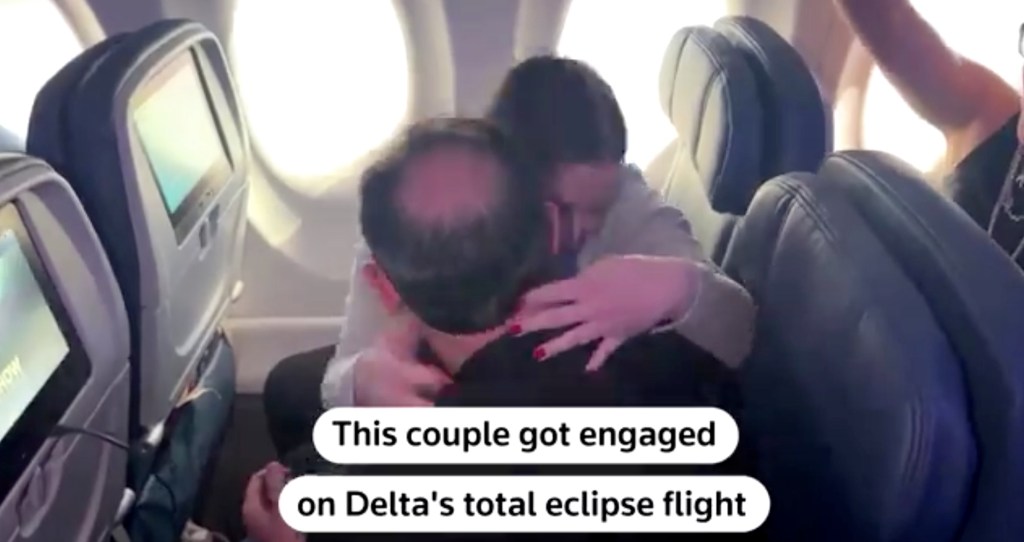 The couple hugging on the flight. 