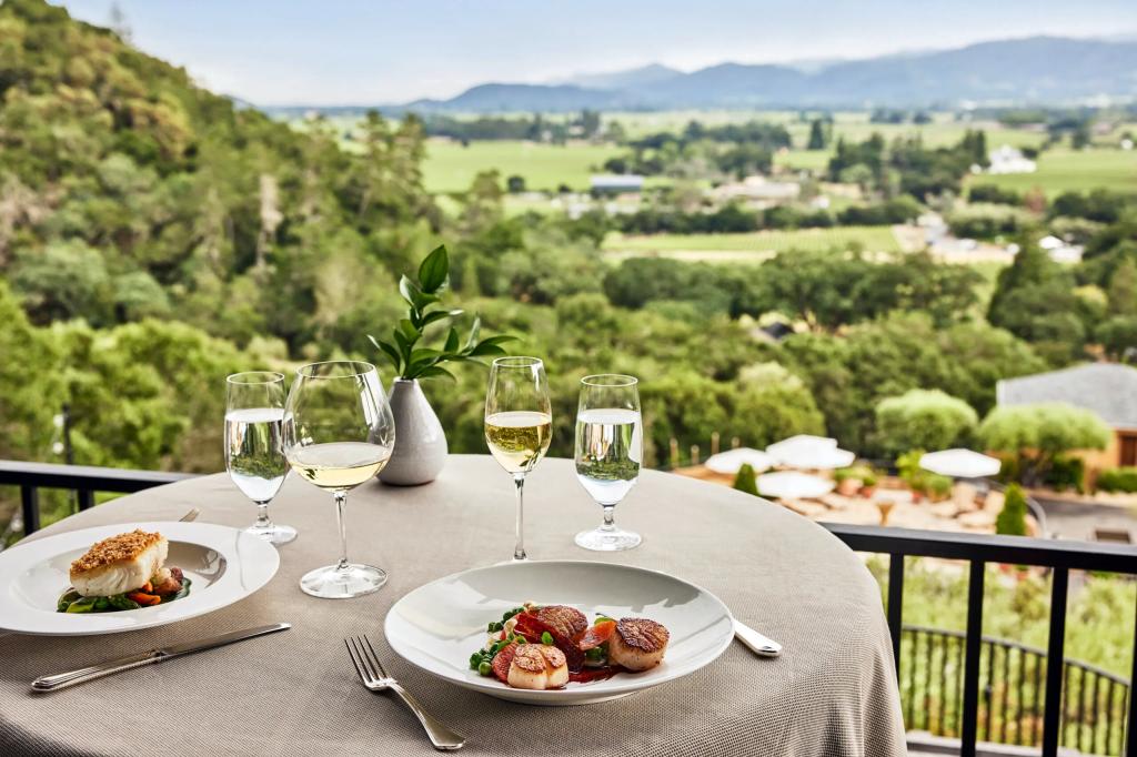 A table with plates of food and wine glasses at Auberge du Soleil, Napa