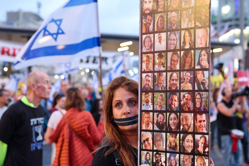A protester holds a sign of the more than 130 hostages who remain under Hamas custody nearly seven months into the war.