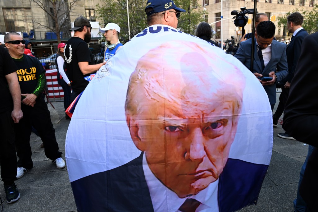 Protesters gather across from New York's criminal courthouse in lower Manhattan on the first day of Donald Trump's hush money trial.