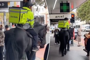 Man in UberEats uniform delivering food while riding a black horse through the streets of Paddington, Sydney