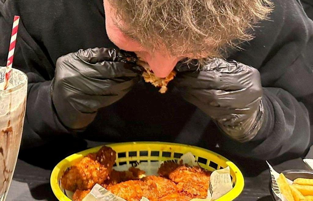 Ollie Leonard trying the 15 chicken wings coated in a Carolina Reaper sauce challenge at Wing Kingz in Canterbury.