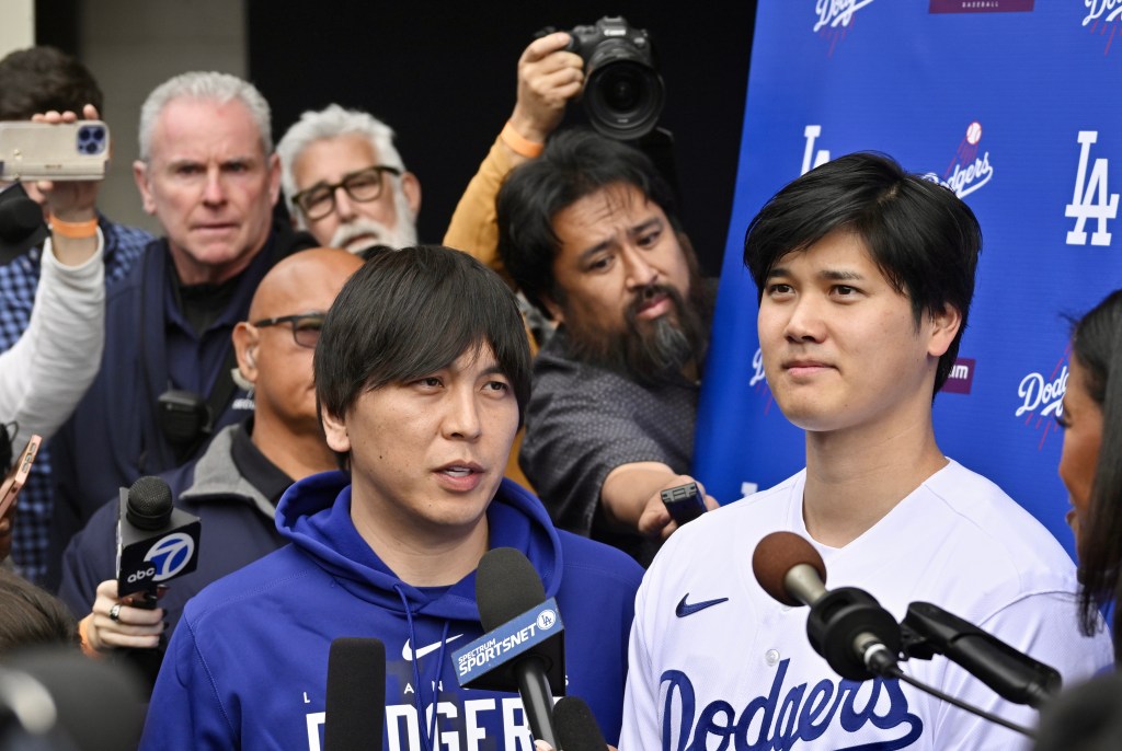 Shohei Ohtani, right, of the Los Angeles Dodgers speaks to the media with the help of his interpreter Ippei Mizuhara, left, during DodgerFest a celebration of the upcoming season.