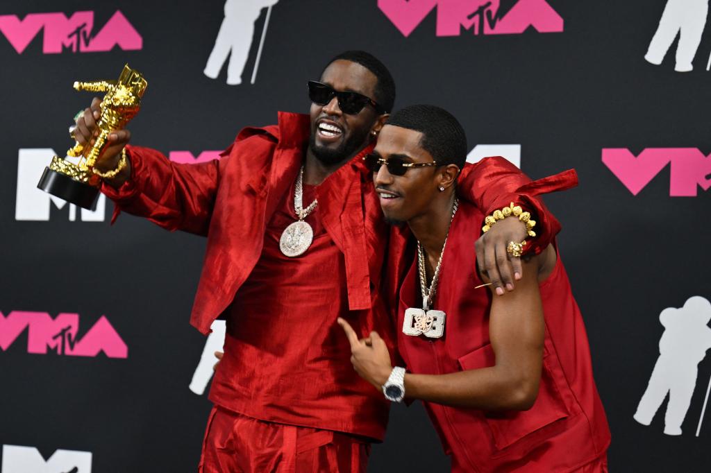 Sean and Christian Combs hold up a trophy and smile at the VMA's.