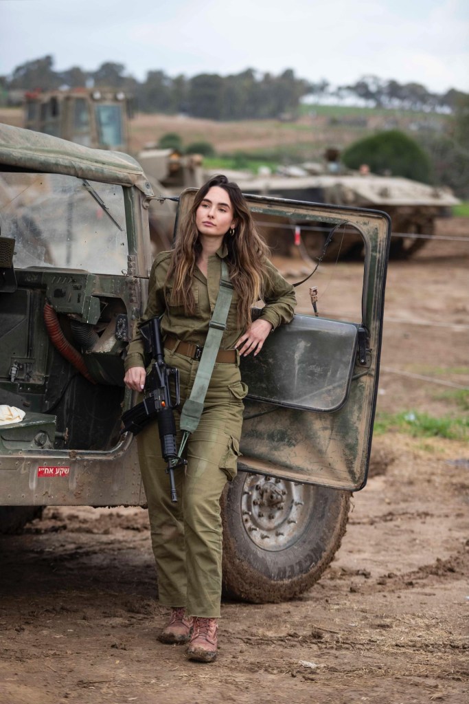 Miss Israel, Noa Cochva, in military uniform standing next to a vehicle, a former IDF battlefield medic and paramedic course commander