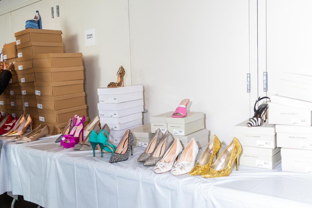 Table full of various dress heels, jewelry, and accessories at a prom clothing giveaway event by the non-profit Operation Prom
