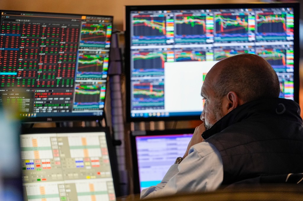 A trader working on the floor of the New York Stock Exchange, looking at multiple computer screens after the opening bell on April 24, 2024