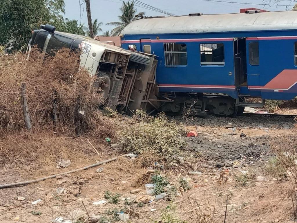 Train colliding with white passenger bus at a level crossing, causing injury to 45 people in Cambodia