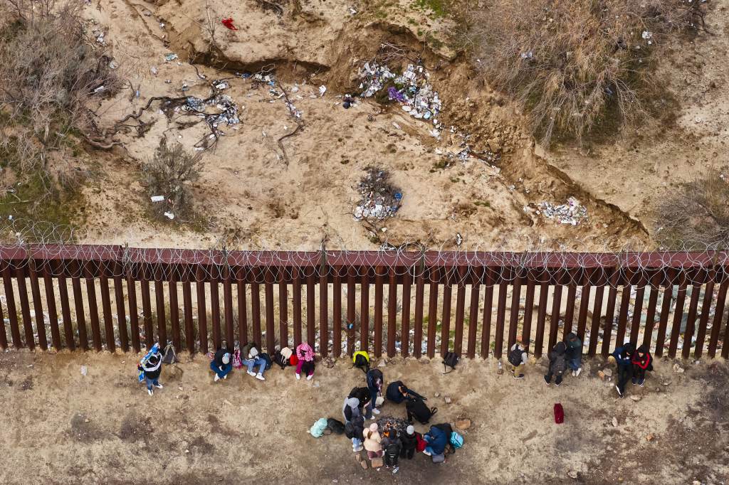 Trash is visible on the Mexico section of the U.S.-Mexico border wall as migrants wait at a makeshift migrant encampment before they turn themselves into U.S. Customs and Border Protection officers after crossing the border on Tuesday, February 20, 2024 near Jacumba Hot Springs, California.