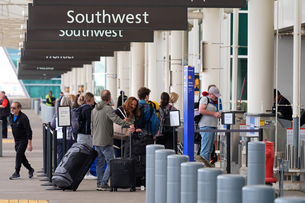 Travelers queue up at curbside check-in for Southwest Airlines Tuesday, April 16, 2024, outside Denver International Airport.