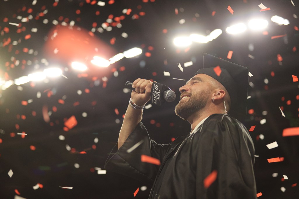 Travis Kelce receives his college diploma during a surprise commencement ceremony during the live taping of his and his brother Jason Kelce’s “New Heights” podcast at Fifth Third Arena in Cincinnati on April 11, 2024. 
