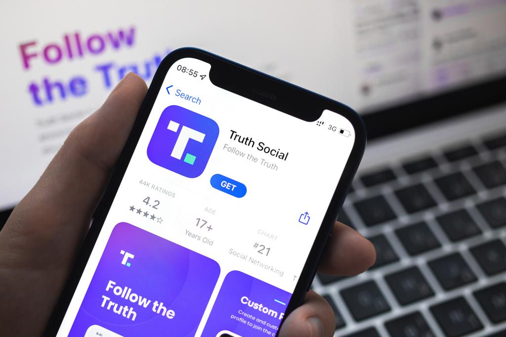 Hand holding a mobile phone displaying the Truth Social app and logo, social media platform by Donald Trump