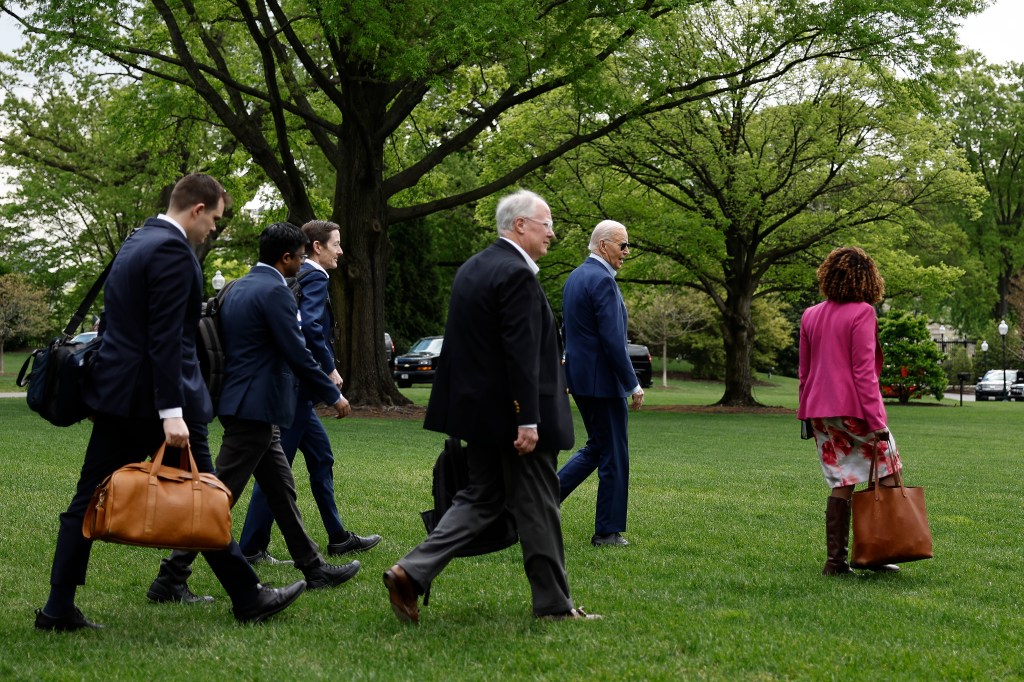 Biden walks to board Marine One with senior members of his staff on the South Lawn of the White House on April 18, 2024.
