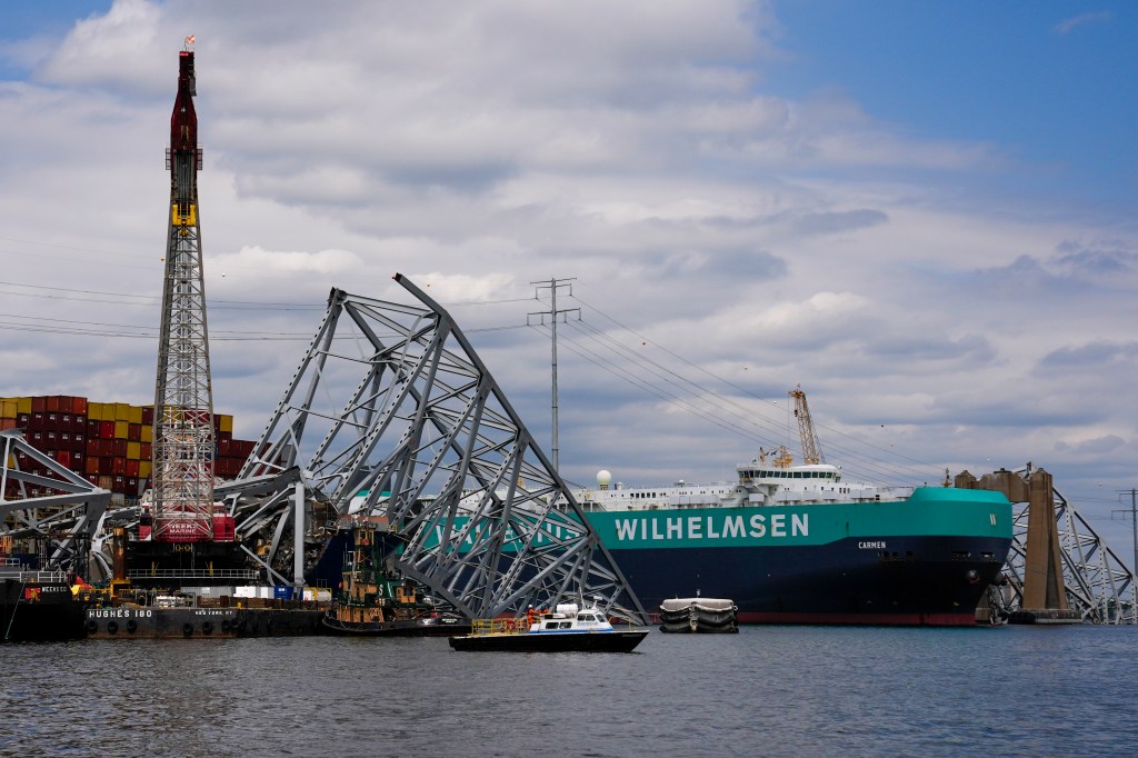 Cargo ship moves past Baltimore Key Bridge wreckage.