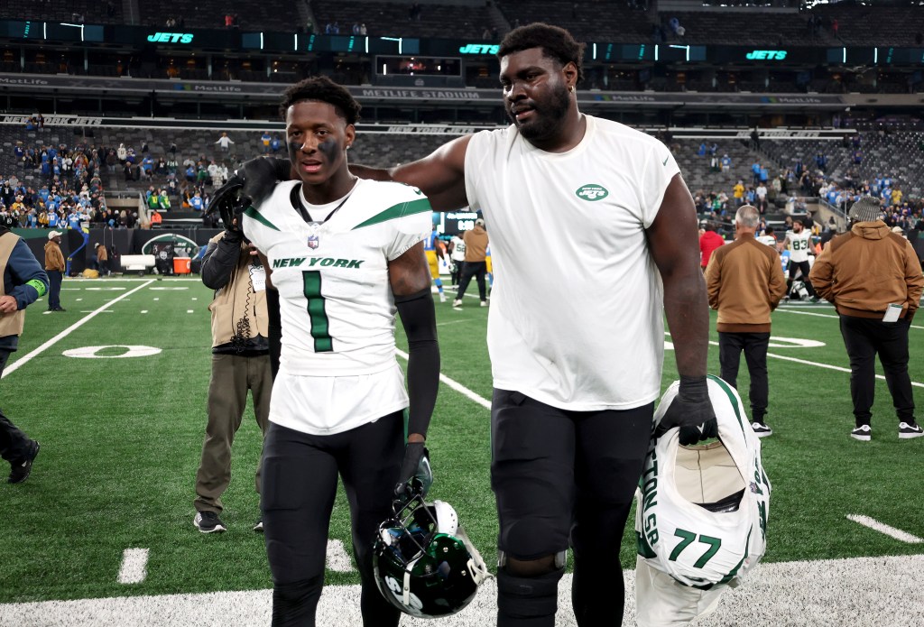 New York Jets offensive tackle Mekhi Becton (77) walks off the field with his arm around New York Jets cornerback Sauce Gardner (1) 