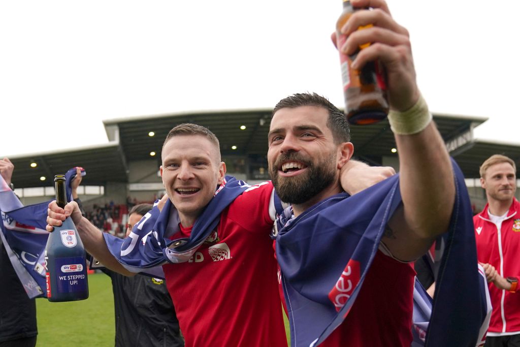 Wrexham's Paul Mullin and Elliot Lee on the pitch celebrating promotion to League One.