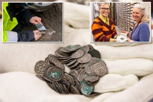 Swedish archaeologist Martina Bunge examining a pile of 12th century silver coins uncovered in a grave during an archaeological dig on Visingsö island.