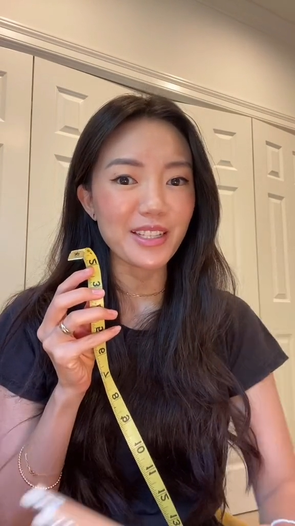 A woman holding a measuring tape, explaining how to determine if a bob hairstyle suits your face shape based on measurement