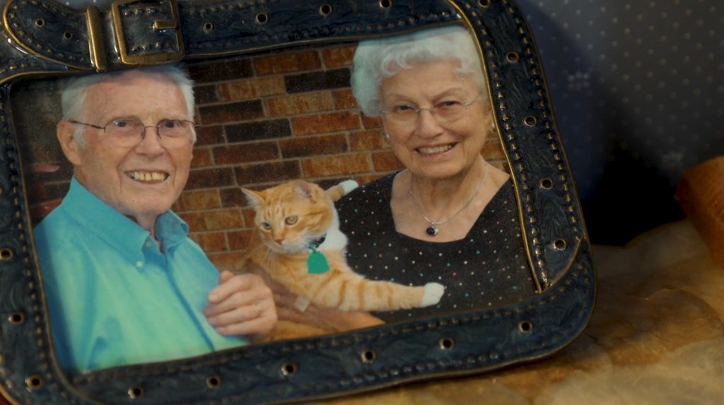 LaVerne and Marion Biser with an orange tabby cat in a framed photograph.