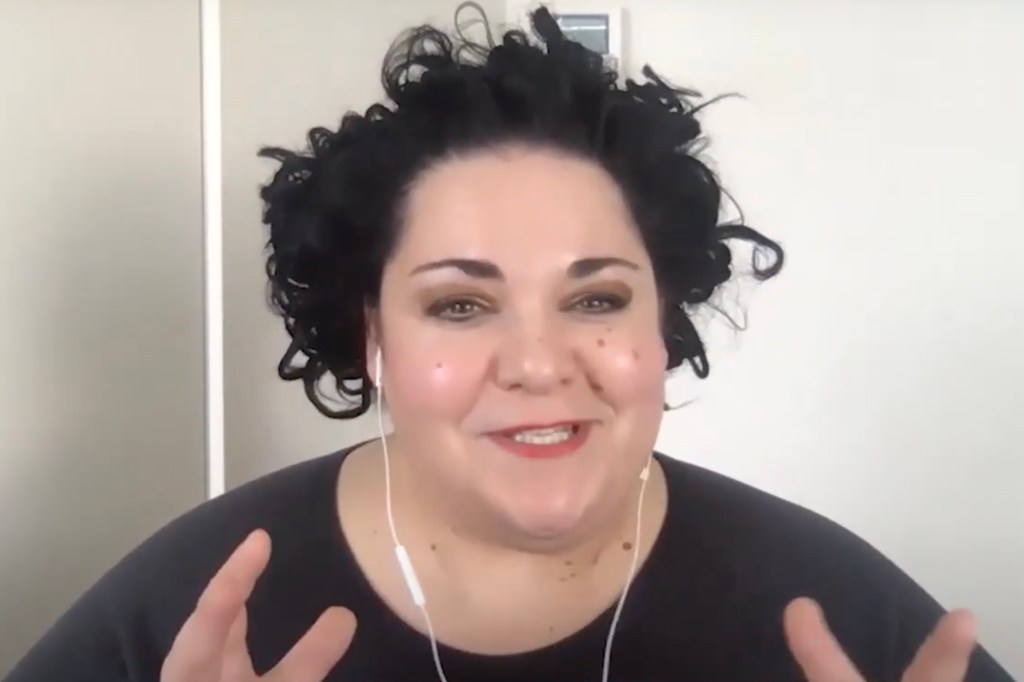 A woman with curly black hair wearing headphones, known as Dr. Lauren Rosewarne