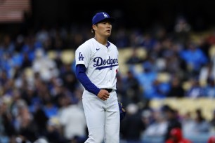 Yoshinobu Yamamoto #18 of the Los Angeles Dodgers walks off the pitching mound after the last out of the first inning making his Dodger Stadium debut against the the St. Louis Cardinals.