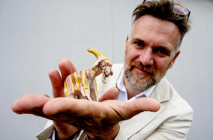 Charles Hanson holding a unique pottery goat sculpture made by King Charles over 50 years ago, expected to auction for £10,000