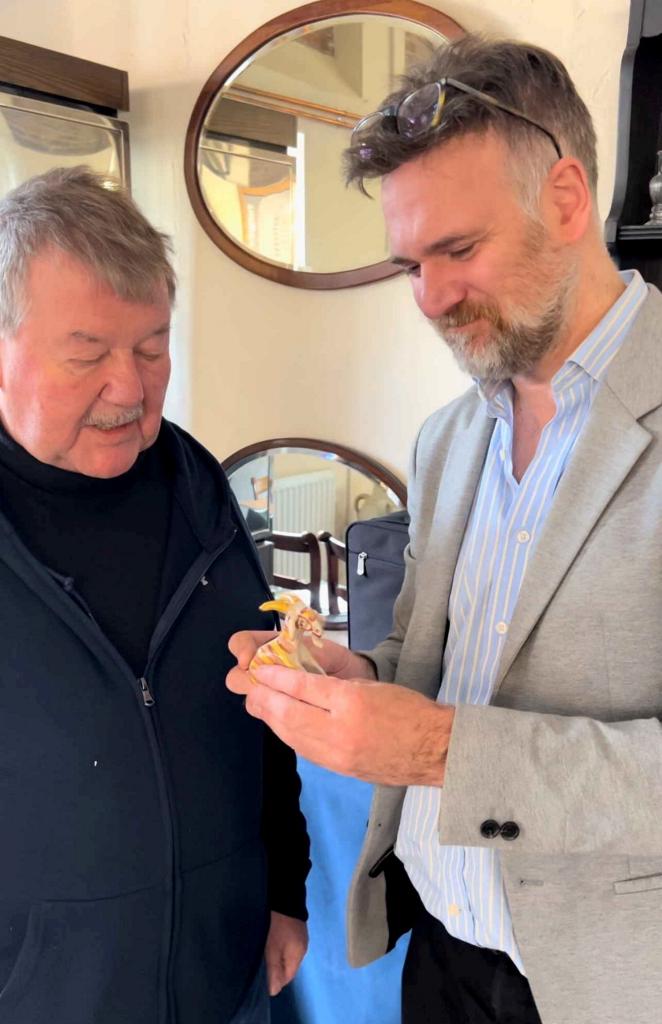 Raymond Patten and Charles Hanson examining a small pottery goat, made by King Charles over 50 years ago, at Bishton Hall.