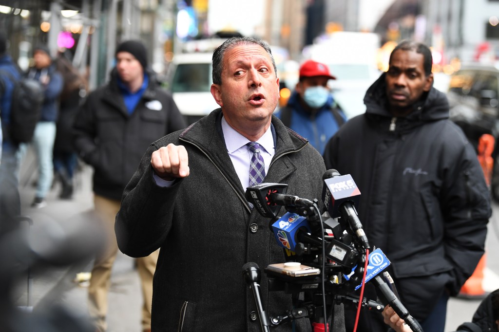 Comptroller Brad Lander speaking into microphones while pointing his finger