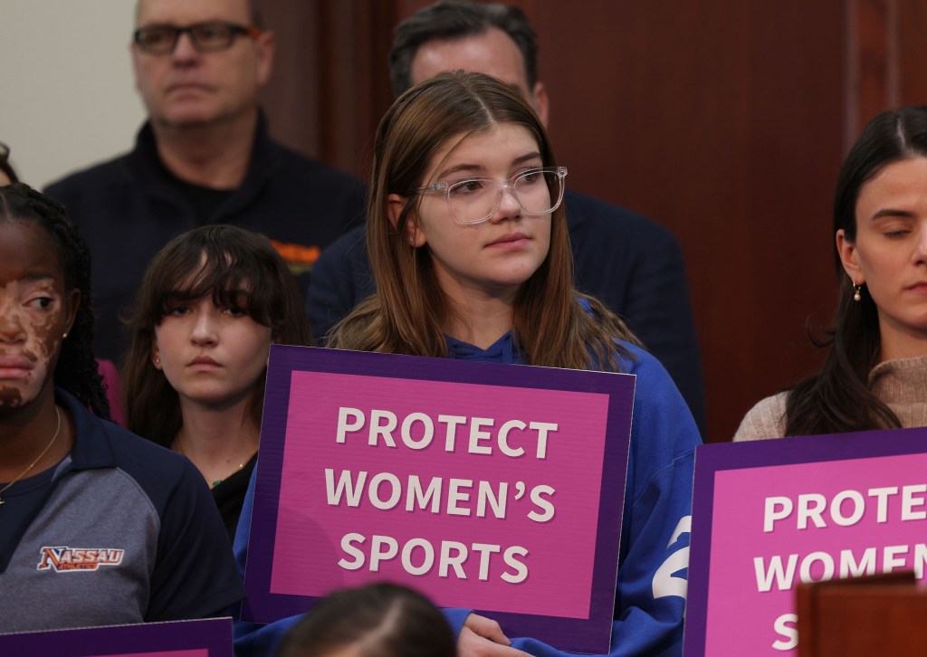 Nassau County Executive Bruce Blakeman with 14-year-old Avery Graziosi and other children, holding signs at a press conference announcing a sports policy plan at the Theodore Roosevelt Building, Mineola, Long Island, NY.