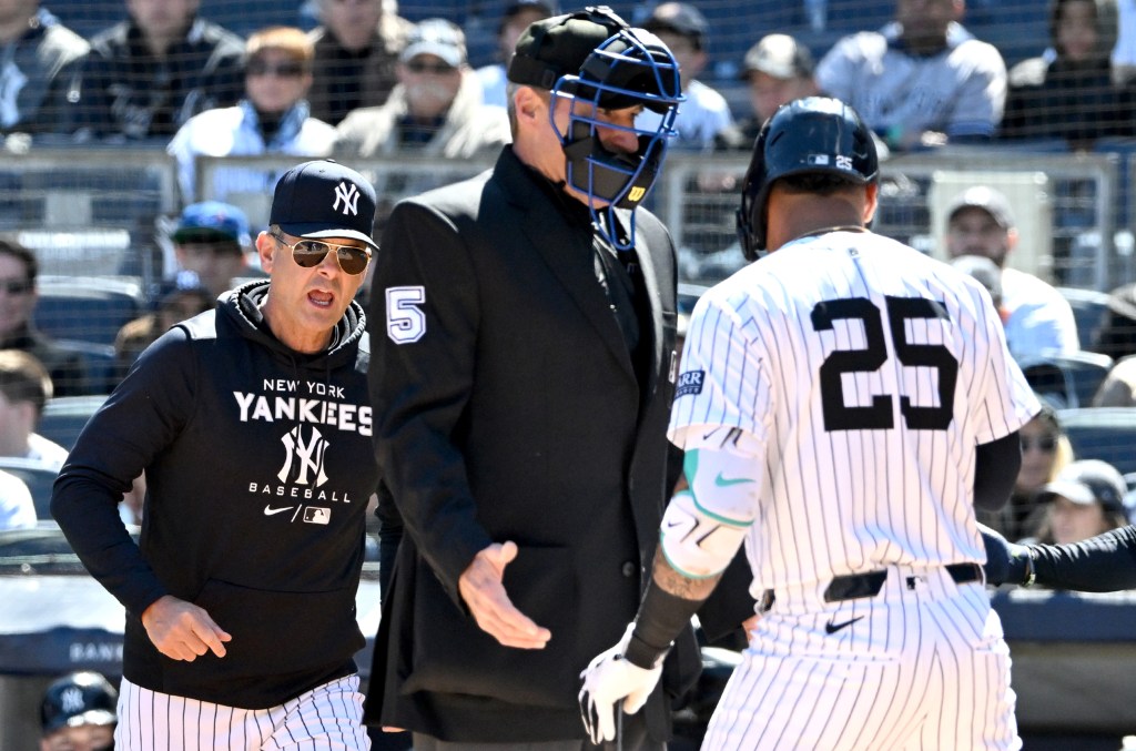 Yankees manager Aaron Boone (17) walks out to argue a call by umpire Angel Hernandez (5) on Yankees second base Gleyber Torres (25) during the 1st inning.