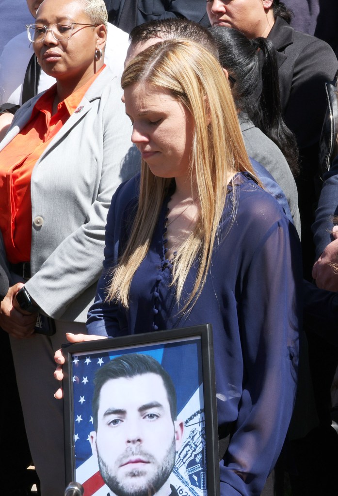 Stephanie Diller holding a photo of her late husband at a press conference.