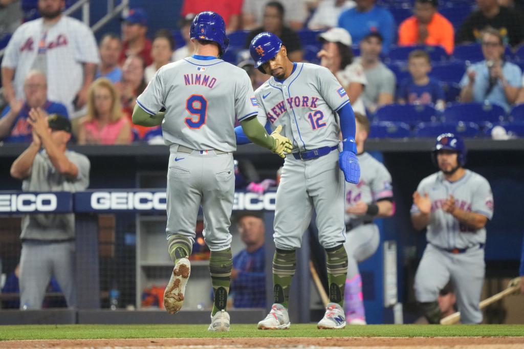 Mets shortstop Francisco Lindor (12) congratulates designated hitter Brandon Nimmo (9) after they both scored in the first inning against the Miami Marlins on Sunday.