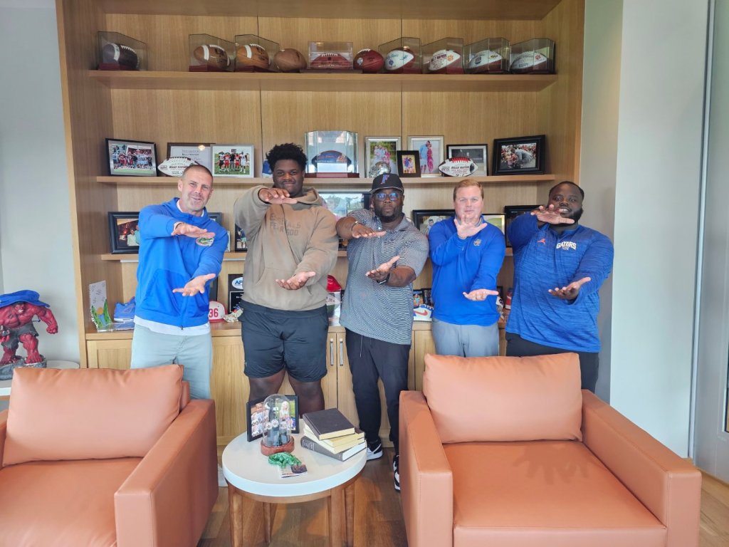 Boireau (second from left) makes the Gator Chomp sign.