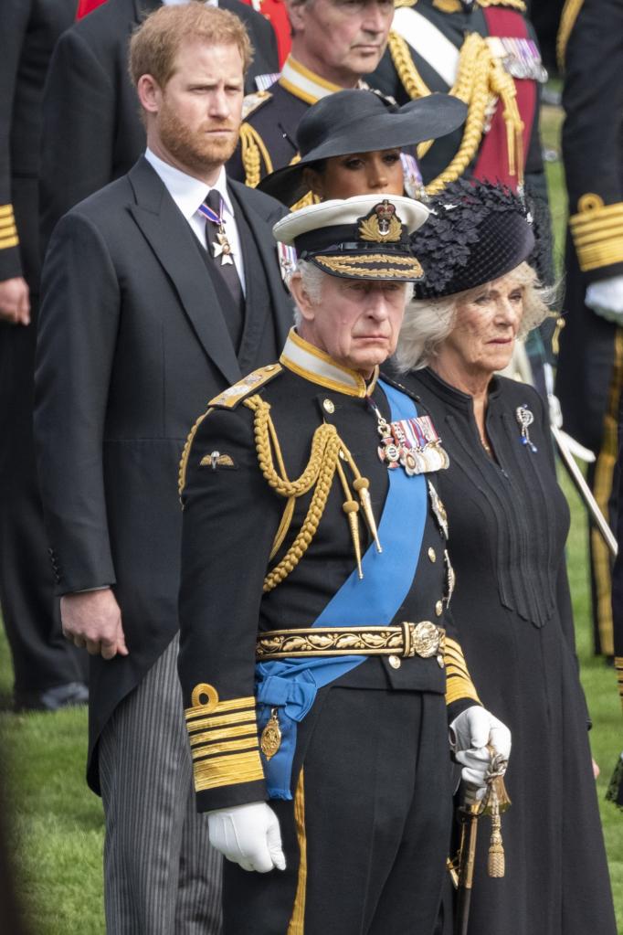 King Charles III, Camilla, Queen Consort, Prince Harry, and Meghan, Duchess of Sussex, observing the procession of Queen Elizabeth II's coffin at Wellington Arch, London