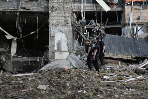 Policemen inspect a heavily damaged office building following a Russian air strike in Kharkiv, on May 25, 2024, amid the Russian invasion of Ukraine.