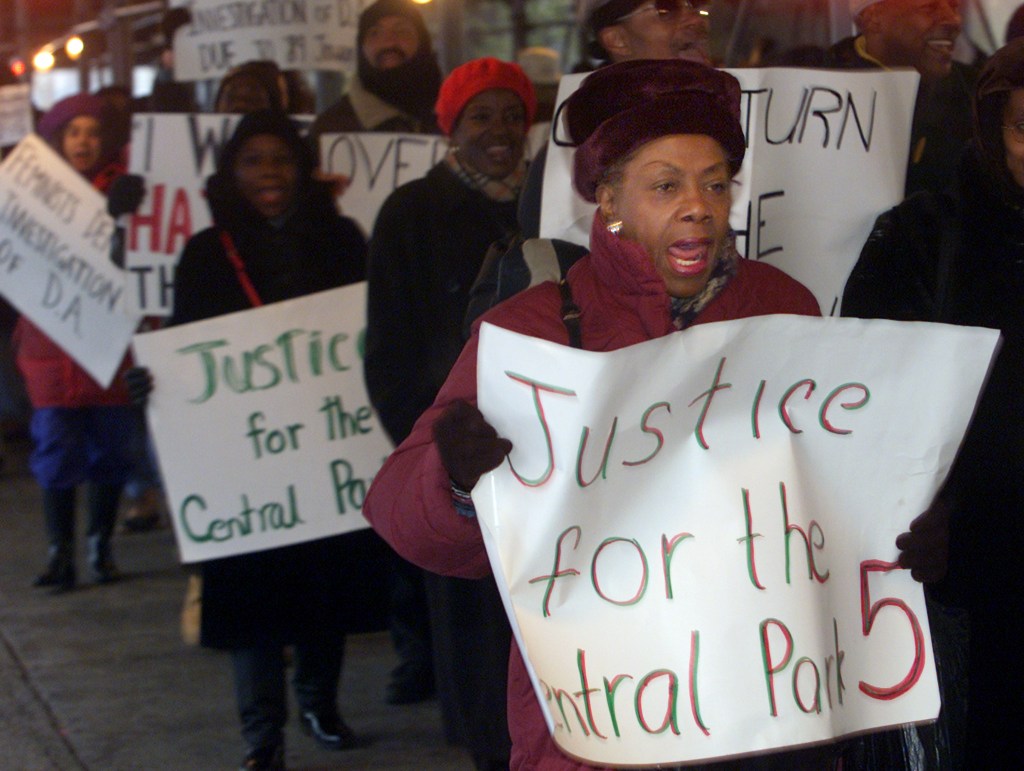 Demonstrators carry signs outside a New York City Court calling for justice in the case of five youths convicted in the 1989 case of sexually assaulting a female jogger in New York's Central Park December 5, 2002.