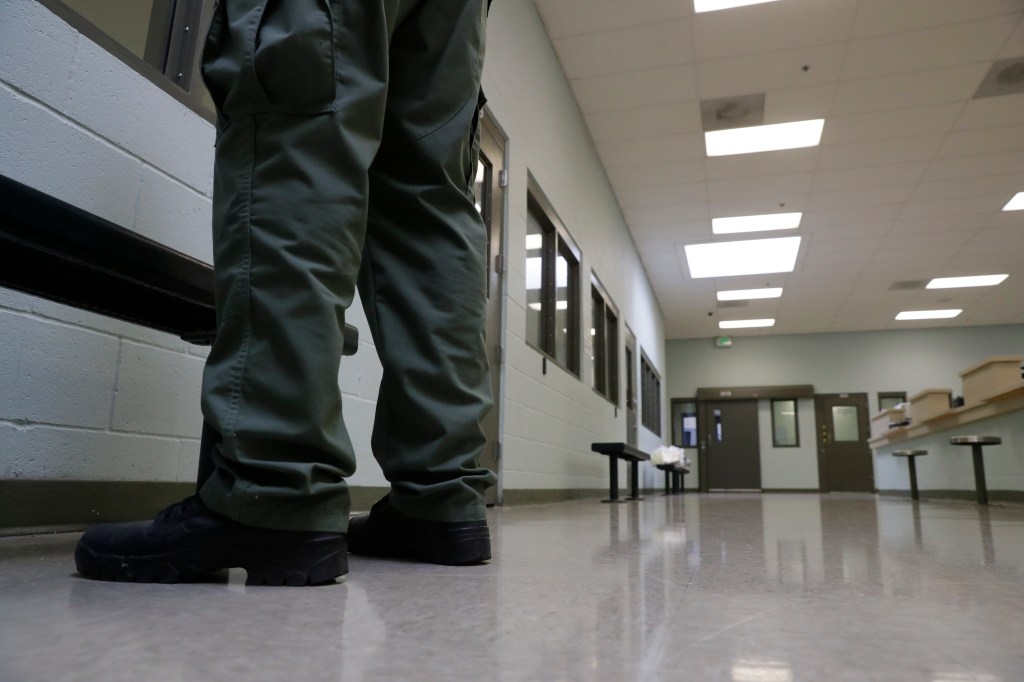 A guard stands in the intake area at the Adelanto ICE Processing Center in Adelanto, Calif.