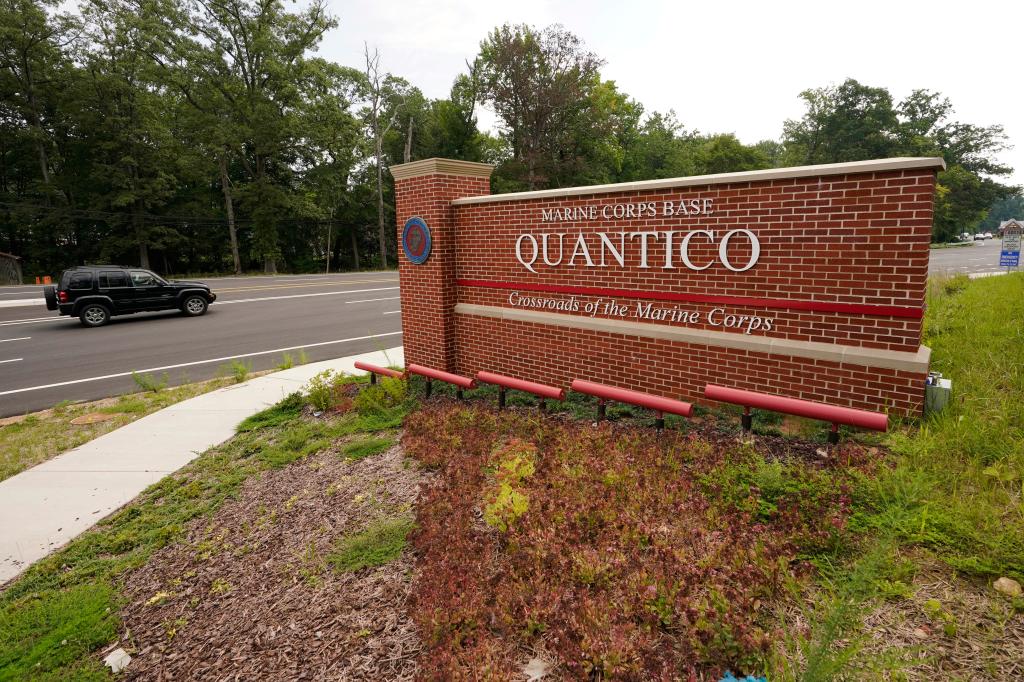 Traffic drives past an entrance sign of Marine Corps Base Quantico
